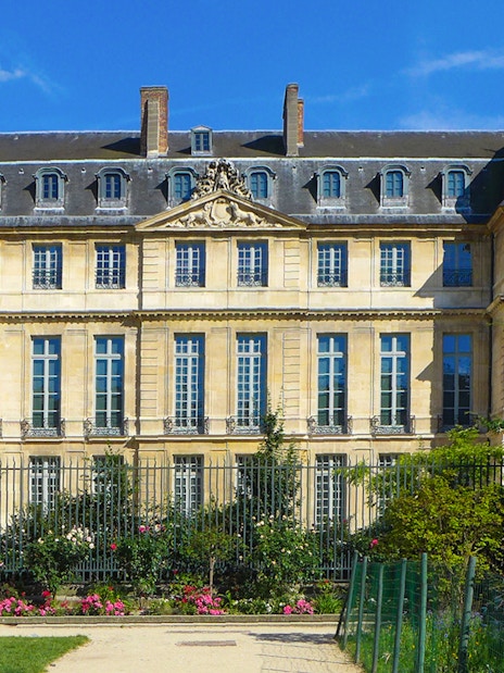 Picasso Museum exterior in Paris with garden and blue sky.