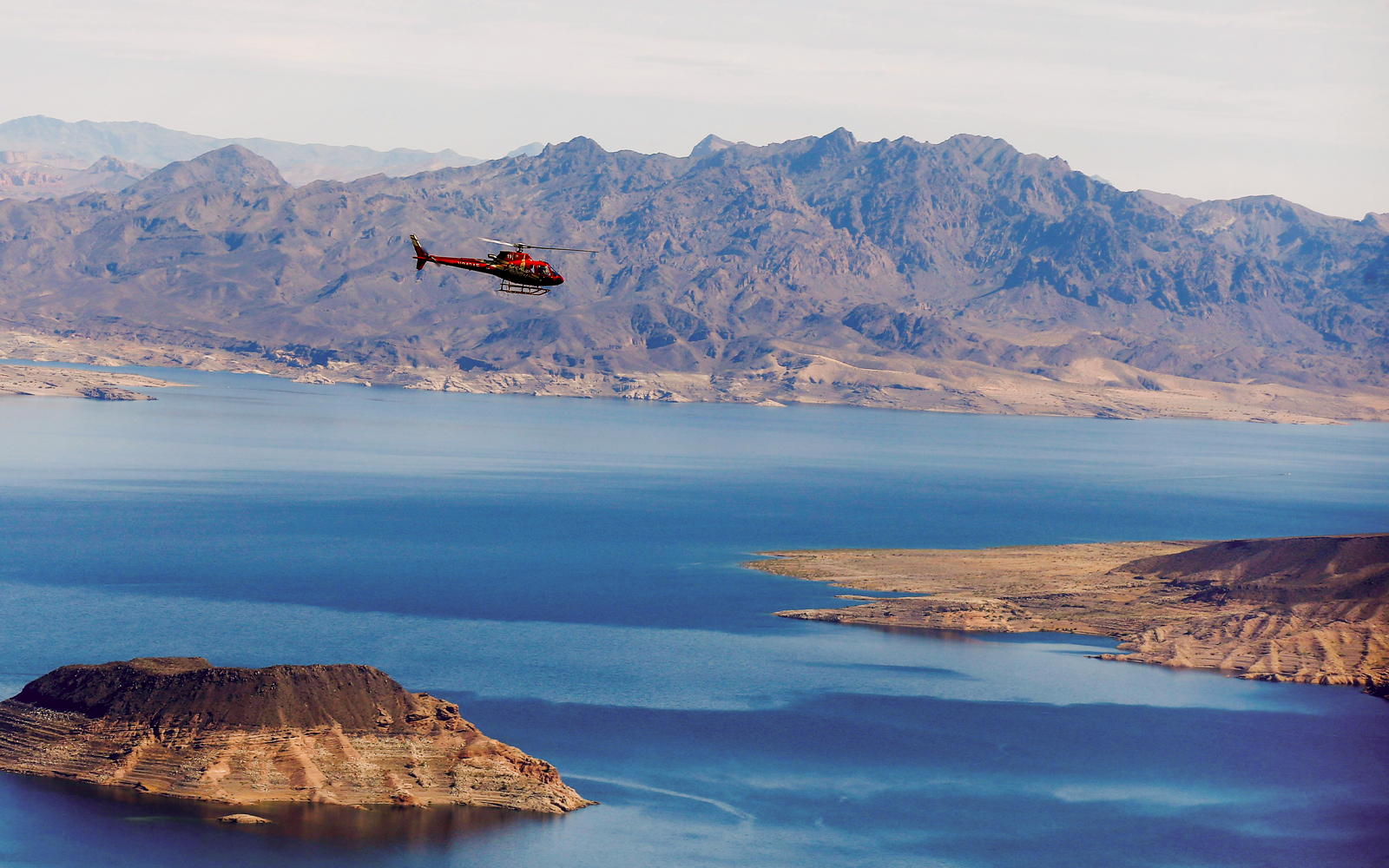Helicopter flying over Lake Mead with mountains in the background during Las Vegas Strip and Hoover Dam tour.