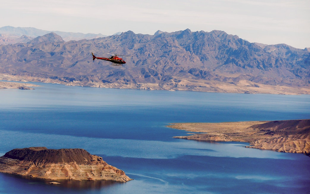 Helicopter flying over Lake Mead with mountains in the background during Las Vegas Strip and Hoover Dam tour.