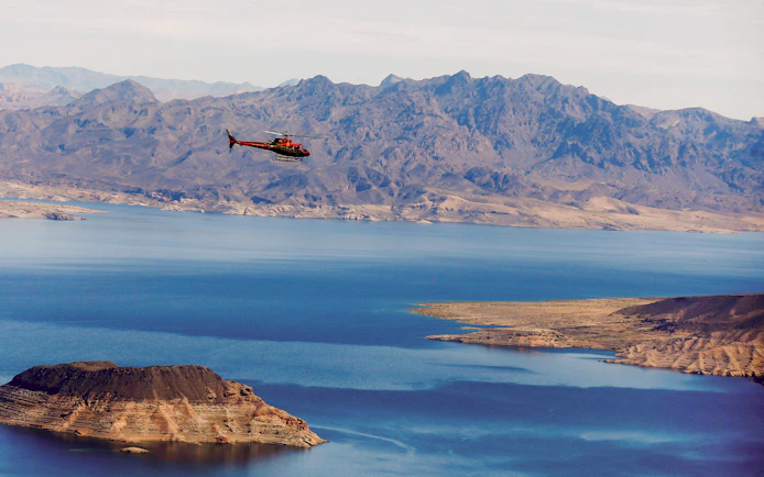 Helicopter flying over Lake Mead with mountains in the background during Las Vegas Strip and Hoover Dam tour.