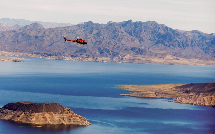 Helicopter flying over Lake Mead with mountains in the background during Las Vegas Strip and Hoover Dam tour.