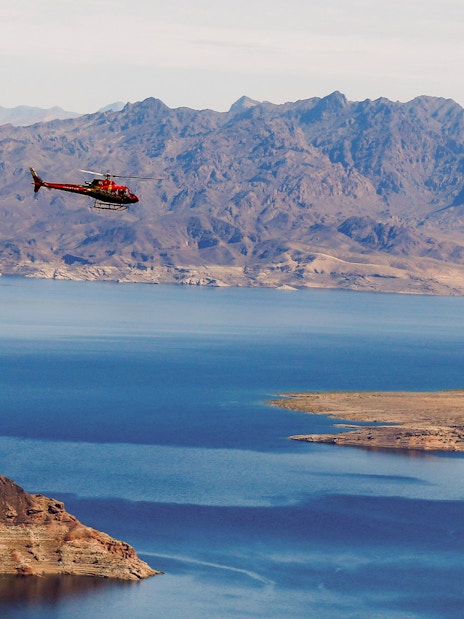 Helicopter flying over Lake Mead with mountains in the background during Las Vegas Strip and Hoover Dam tour.