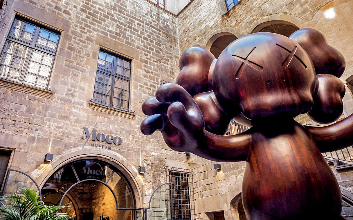 Moco Museum entrance in Barcelona with large sculpture, featuring Banksy artworks.