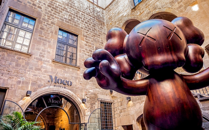 Moco Museum entrance in Barcelona with large sculpture, featuring Banksy artworks.