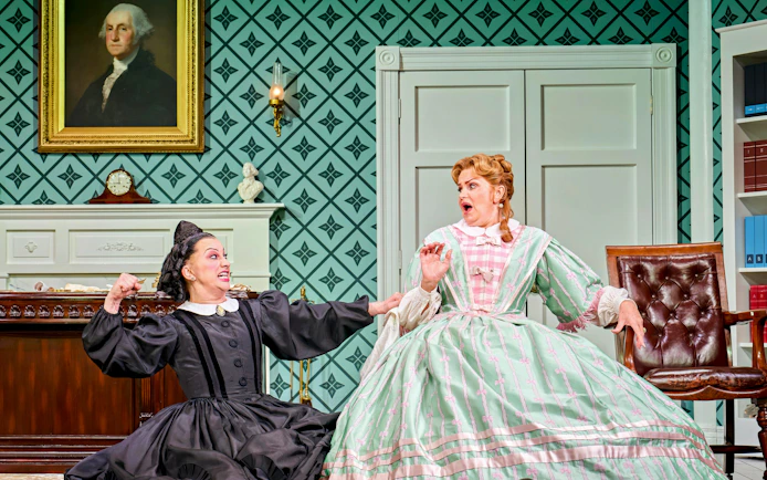 Two actors in period costumes performing a scene from "Oh Mary!" in a vintage room.