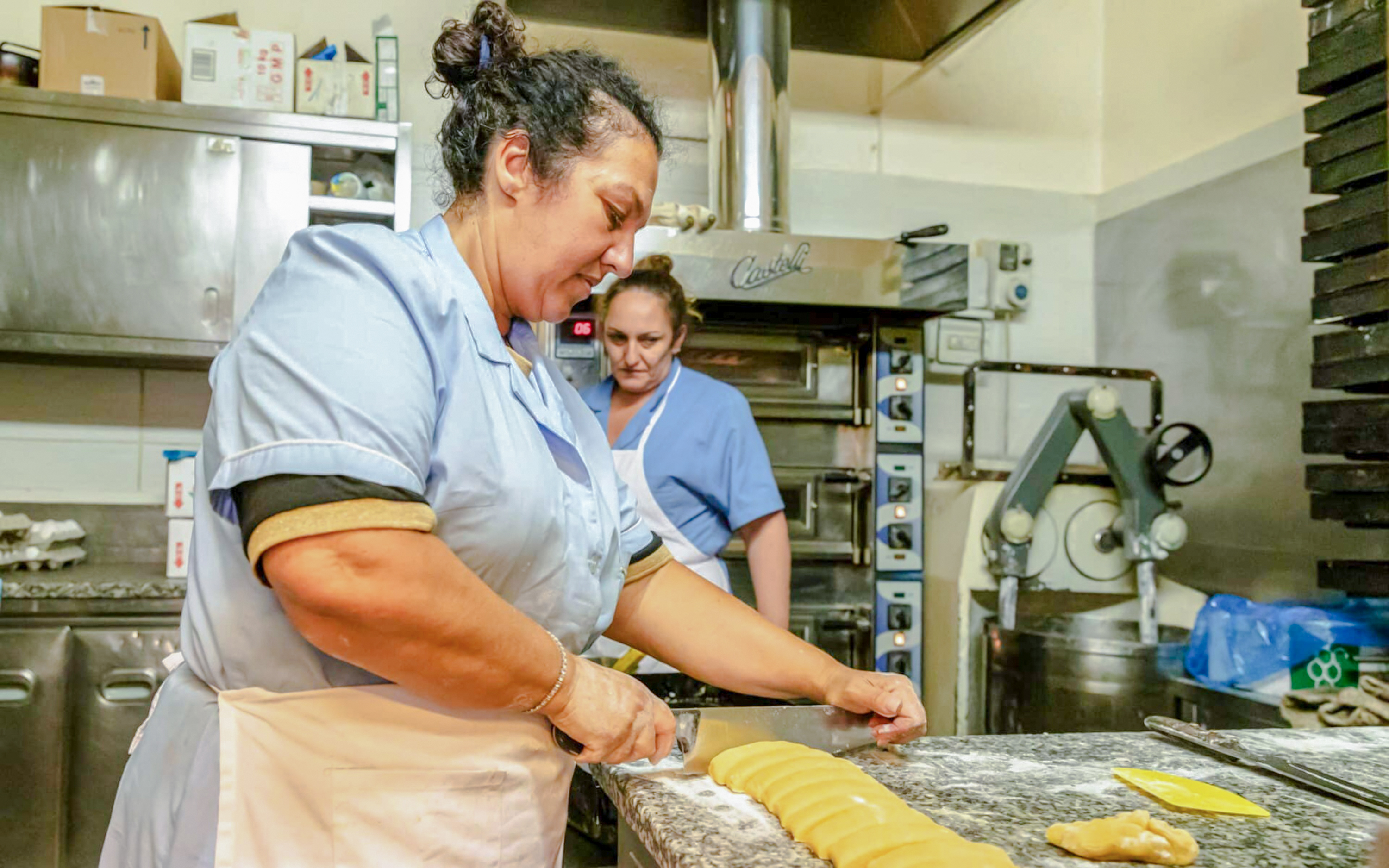 Woman preparing traditional Jewish-Roman cake in a historic bakery, Rome food tour.