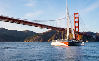 Sailboat cruising under Golden Gate Bridge in San Francisco Bay.