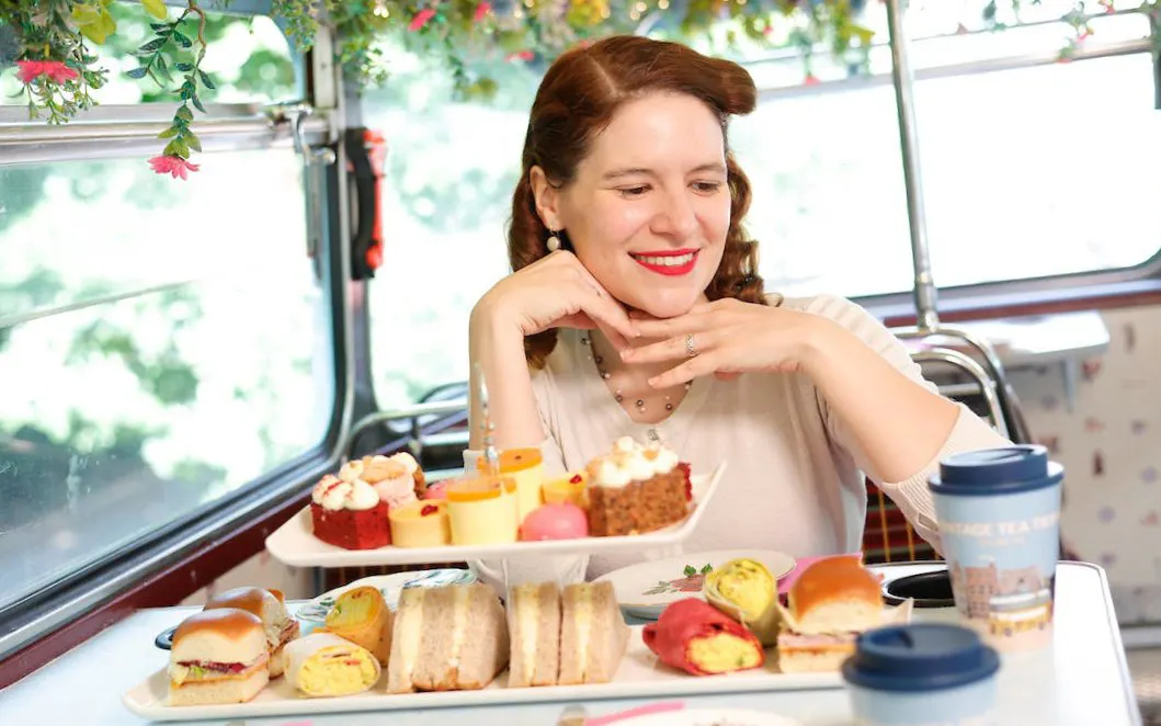 Vintage tea tour with pastries and sandwiches on a bus.