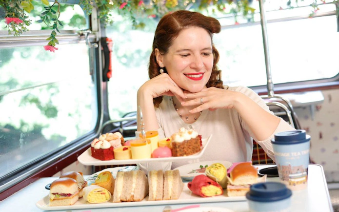 Vintage tea tour with pastries and sandwiches on a bus.