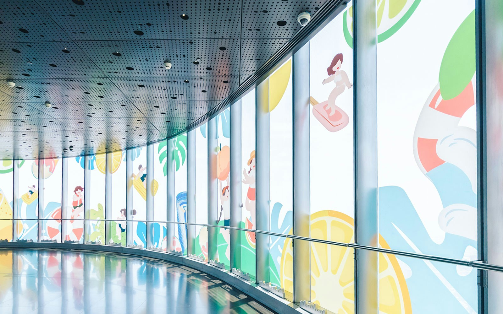 Curved hallway in Shanghai Tower with colorful window decorations.