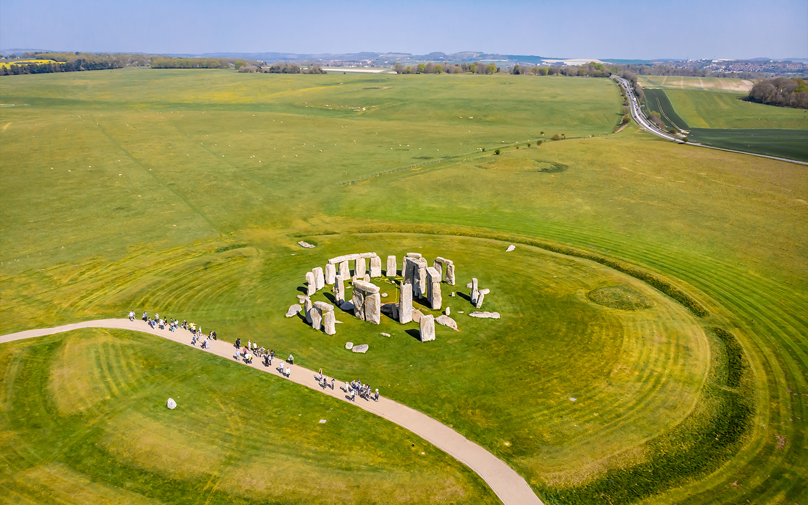 Aerial view of Stonehenge surrounded by green fields in England.