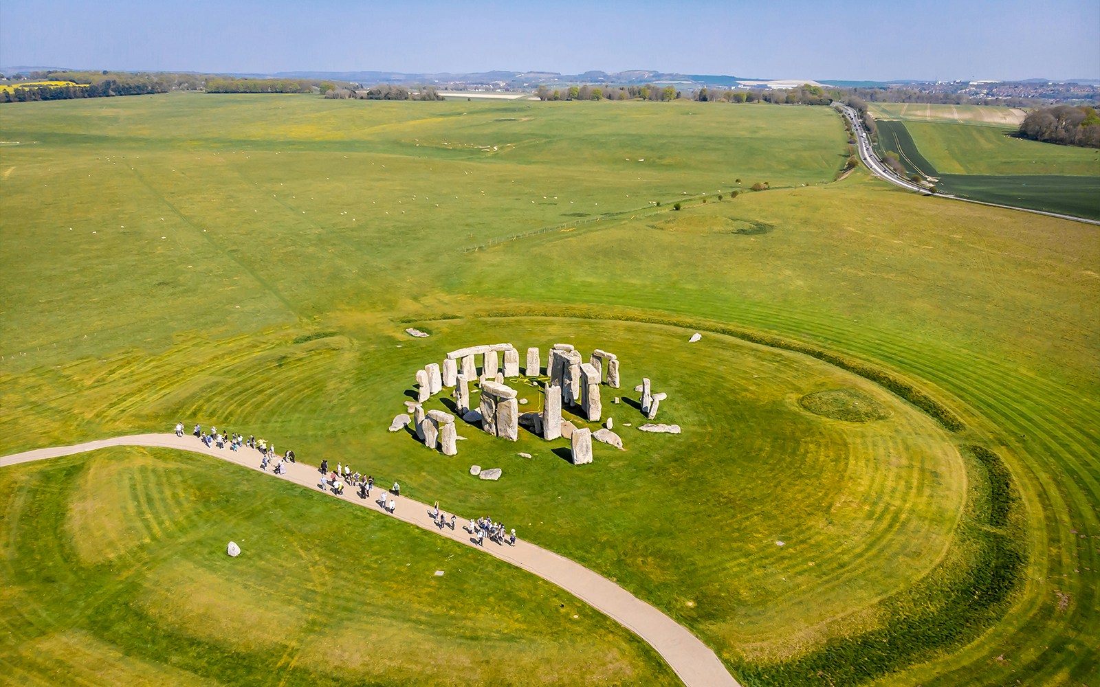 Aerial view of Stonehenge surrounded by green fields in England.