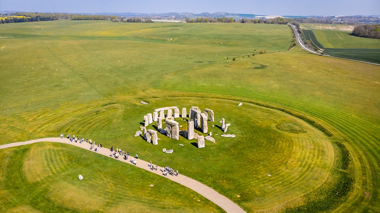 Aerial view of Stonehenge surrounded by green fields in England.