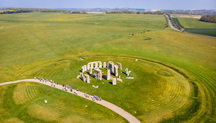 Aerial view of Stonehenge surrounded by green fields in England.