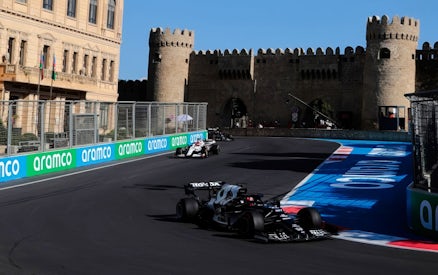 Formula 1 cars racing past historic walls at Azerbaijan Grand Prix 2026 in Baku.