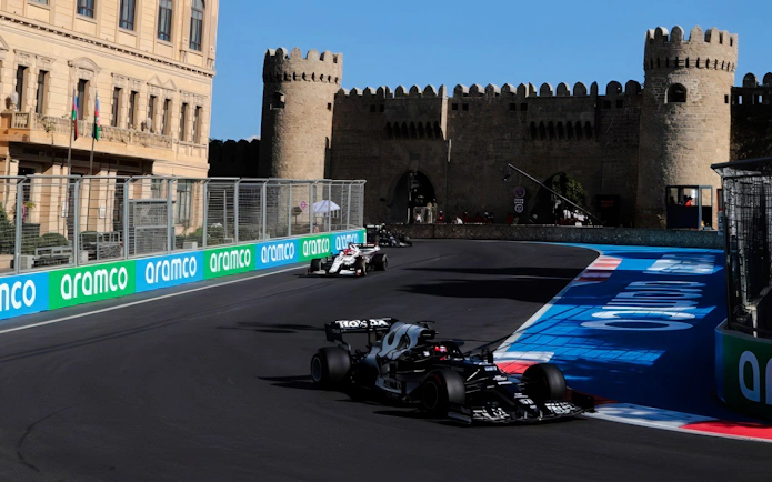 Formula 1 cars racing past historic walls at Azerbaijan Grand Prix 2026 in Baku.