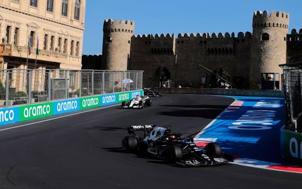 Formula 1 cars racing past historic walls at Azerbaijan Grand Prix 2026 in Baku.