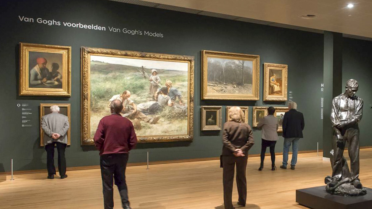 Tourists viewing paintings and sculpture inside Van Gogh Museum, Amsterdam.