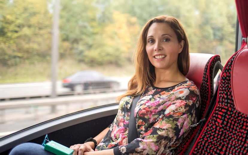 Person enjoying a scenic bus ride on the Stratford, Oxford, Cotswolds & Warwick Castle Tour.