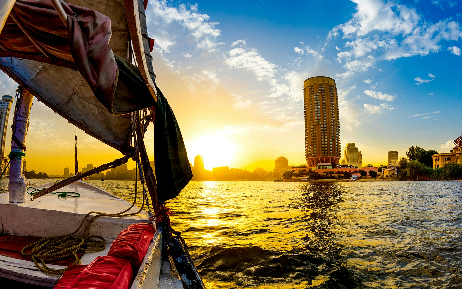 Felucca sailing on the Nile at sunset with Cairo skyline in the background, Egypt.