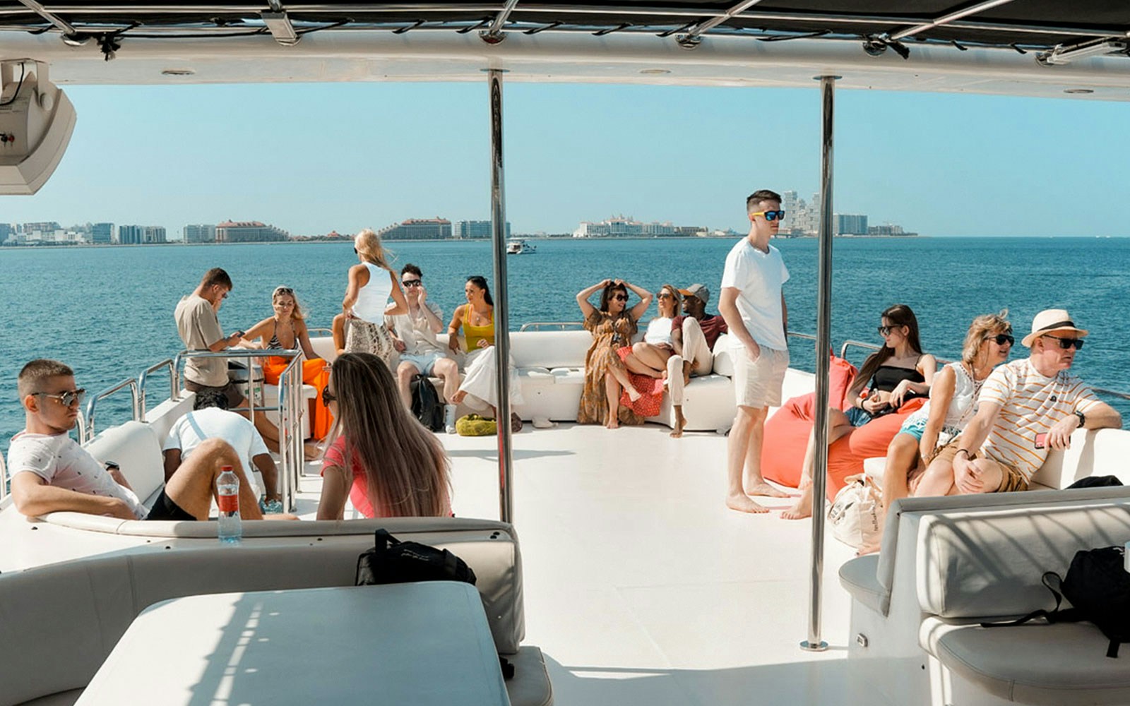 Tourists on a luxury yacht cruise in Dubai Marina enjoying the skyline view.