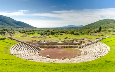 Ancient Messene theater ruins surrounded by green hills, Peloponnese, Greece.