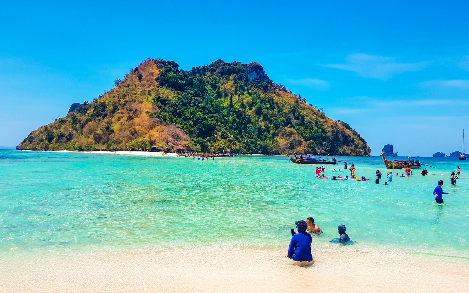 Tourists enjoying the clear waters and sandy beach of Thale Waek Island, Krabi.
