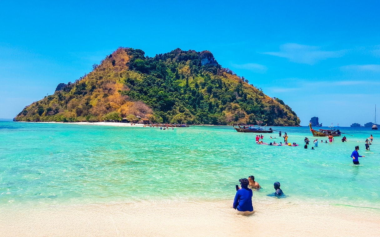 Tourists enjoying the clear waters and sandy beach of Thale Waek Island, Krabi.