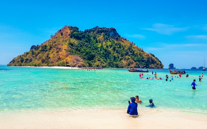 Tourists enjoying the clear waters and sandy beach of Thale Waek Island, Krabi.