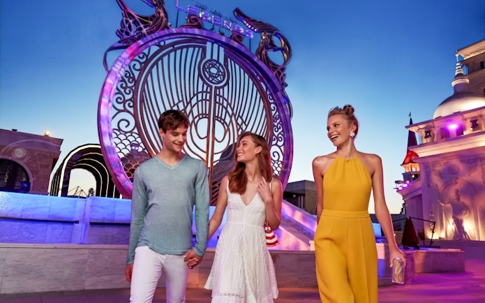 Visitors enjoying an evening at The Land Of Legends Theme Park with illuminated architecture.