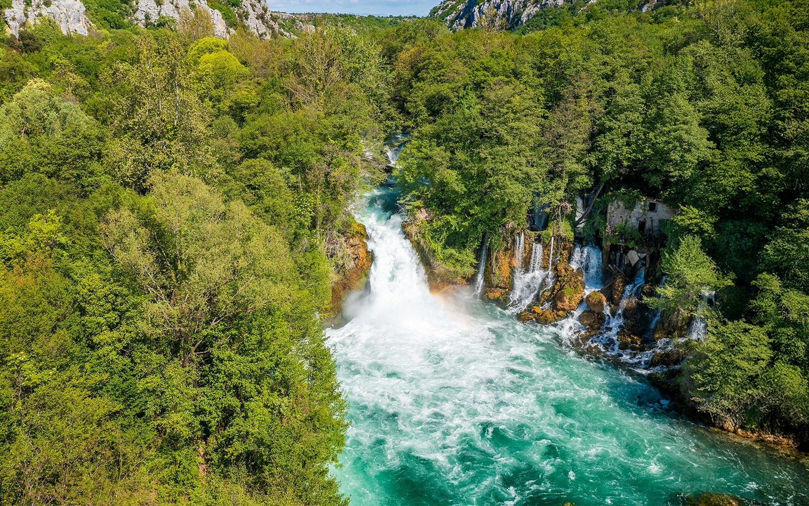 Aerial view of Bilusica buk waterfall cascading through lush greenery in Krka National Park, Croatia.