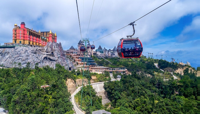 Cable car ascending to Ba Na Hills in Da Nang, Vietnam, with lush green mountains in the background.
