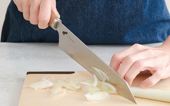 Chef slicing onion at Tokyo cooking class for ramen and gyoza.