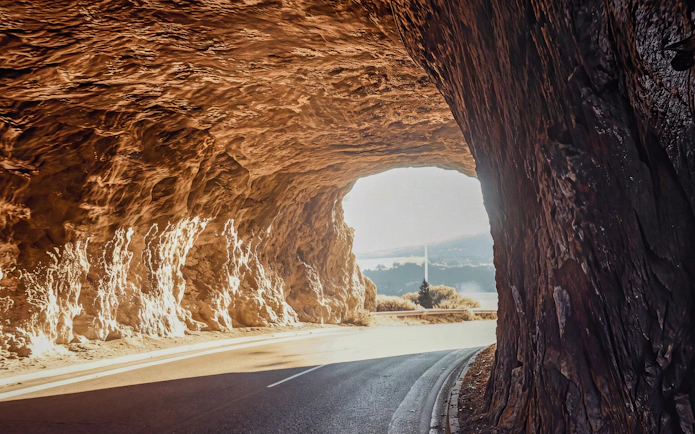 Tunnel view on Sounion Half-Day Tour with coastal landscape in the distance.