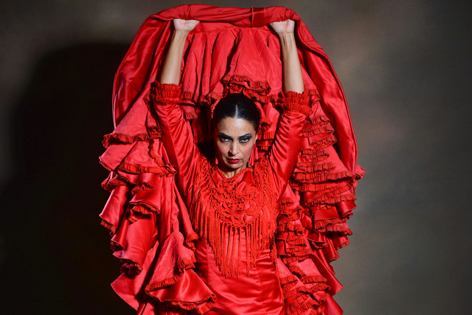 Flamenco dancer in red dress performing at Teatro Flamenco Barcelona.