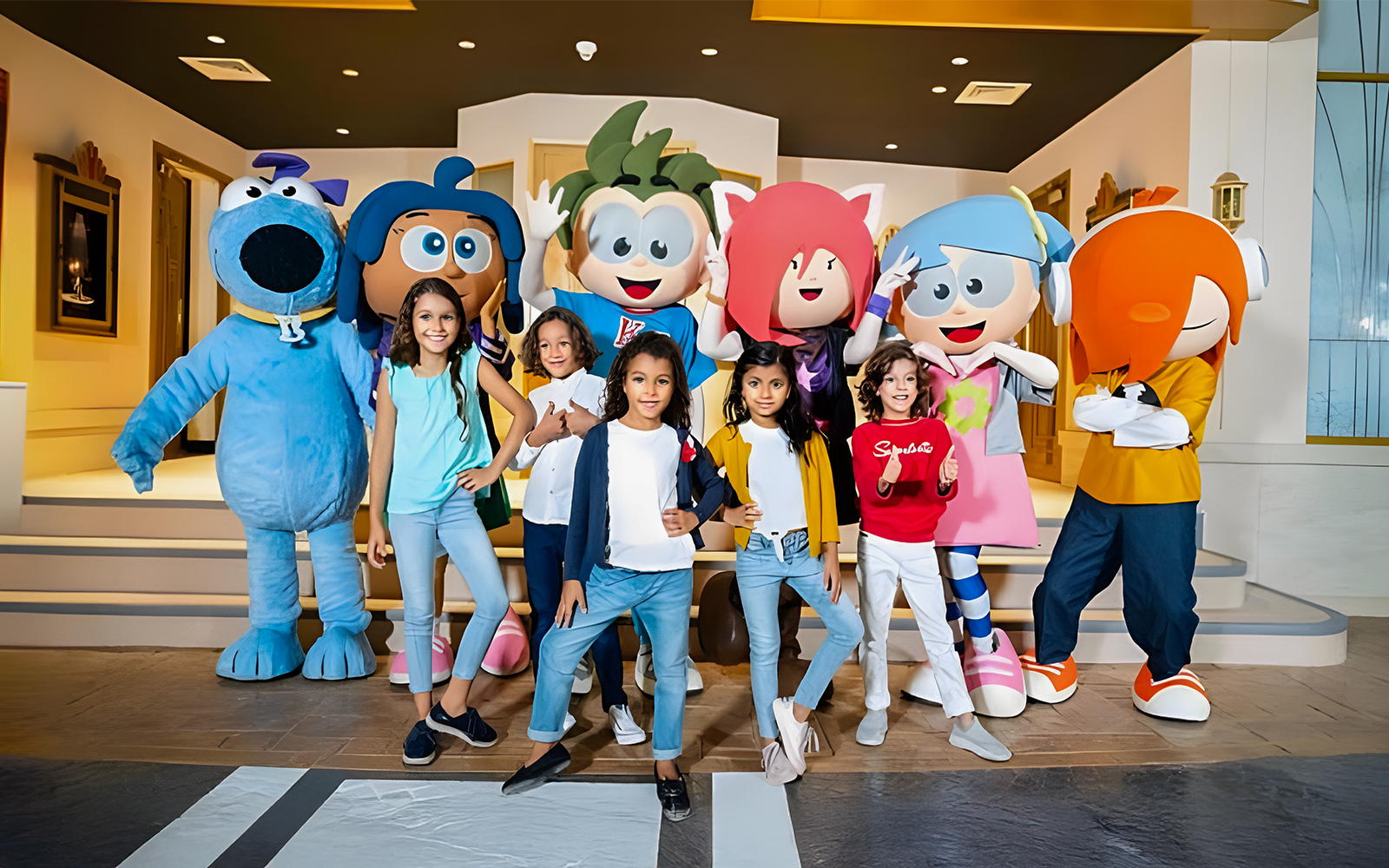 Kids posing with mascots at KidZania, Abu Dhabi.