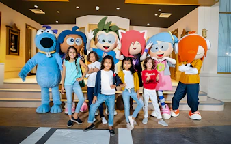 Kids posing with mascots at KidZania, Abu Dhabi.