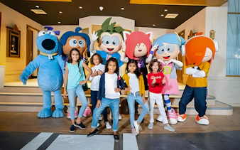 Kids posing with mascots at KidZania, Abu Dhabi.