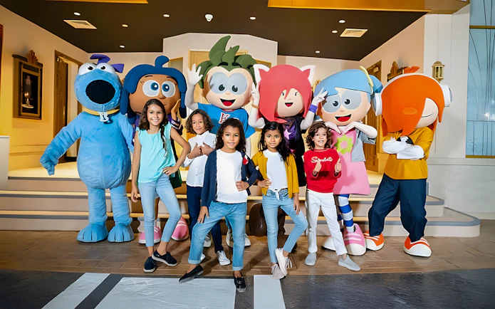 Kids posing with mascots at KidZania, Abu Dhabi.