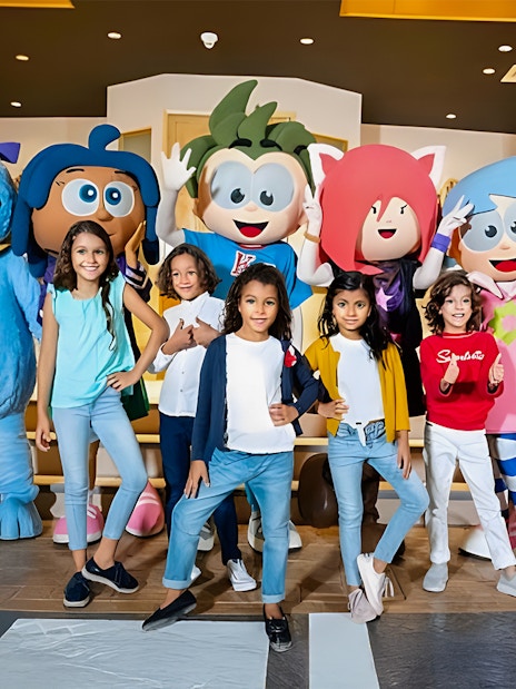 Kids posing with mascots at KidZania, Abu Dhabi.