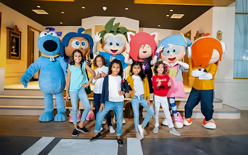 Kids posing with mascots at KidZania, Abu Dhabi.