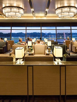 Plaza Premium Lounge Singapore with seating and view of airport runway.