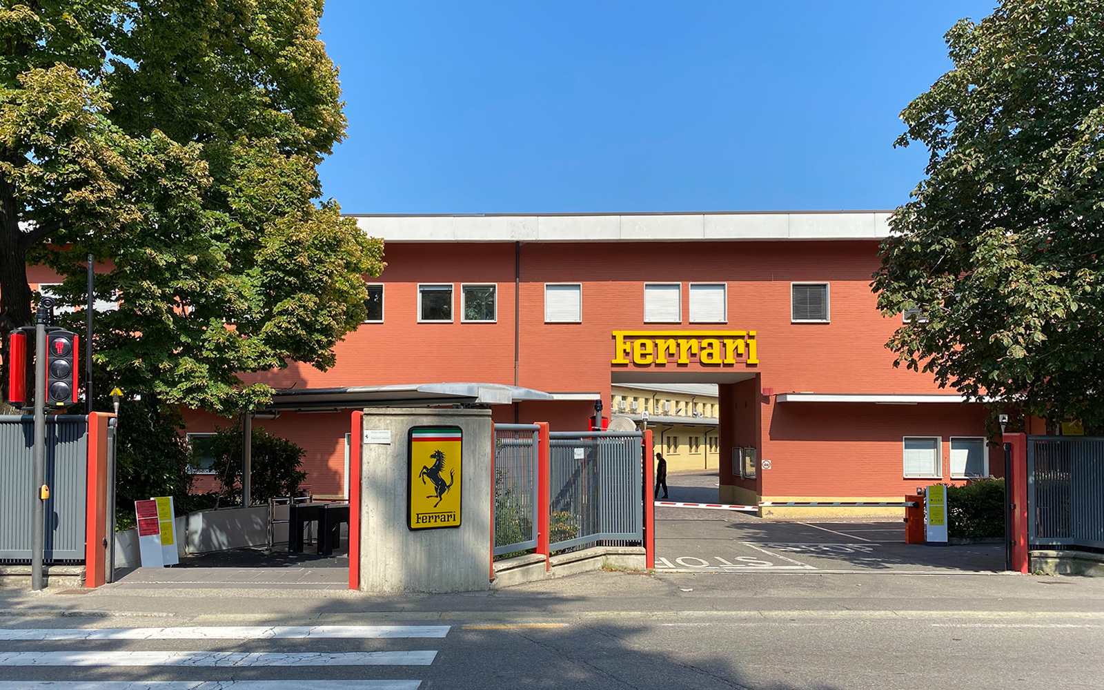Ferrari Maranello Factory entrance with iconic logo and red building.