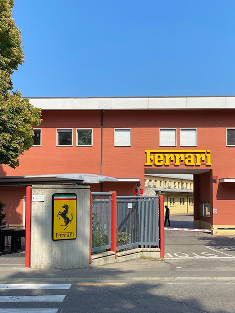 Ferrari Maranello Factory entrance with iconic logo and red building.