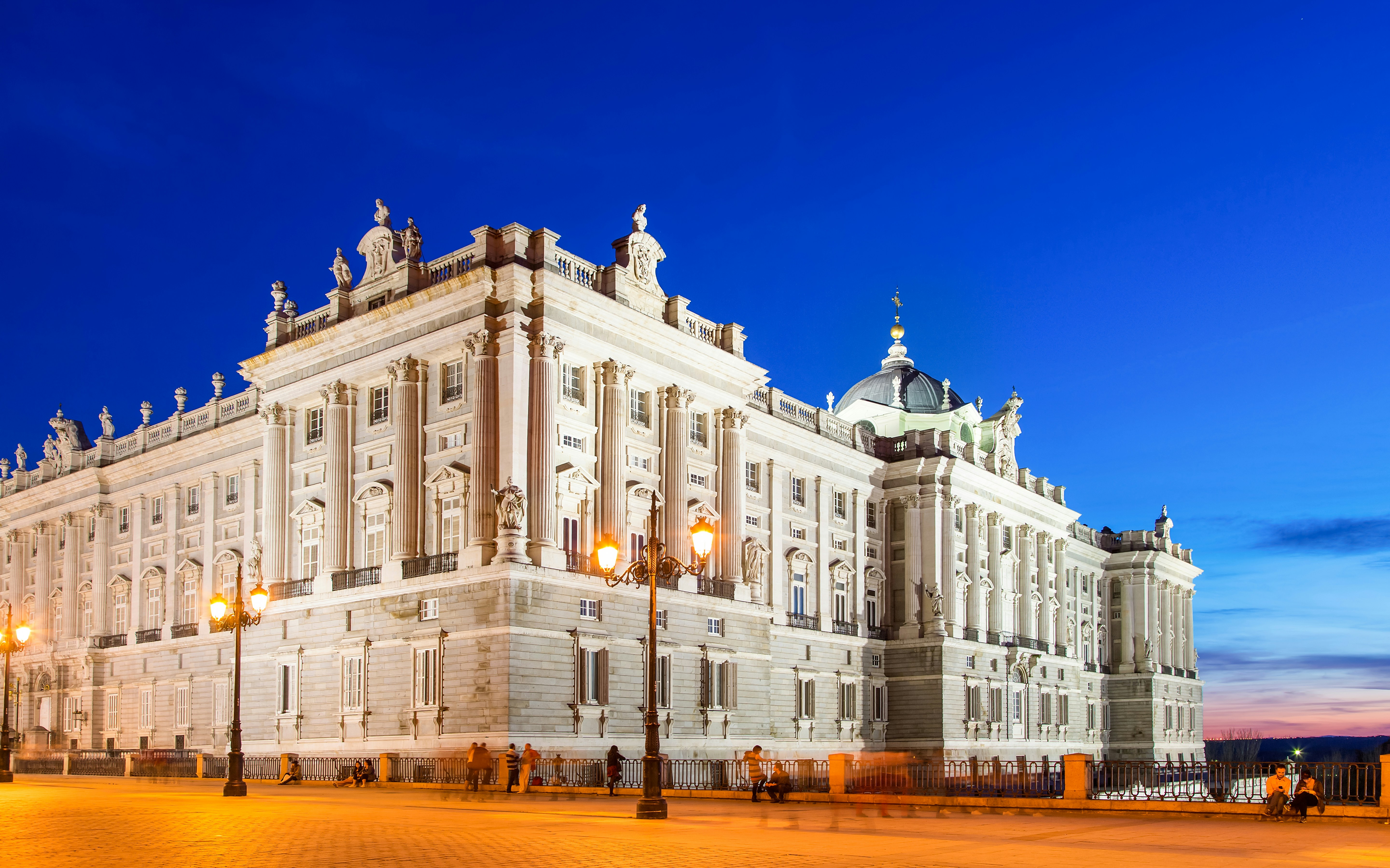 Royal Palace of Madrid illuminated at night with clear sky.
