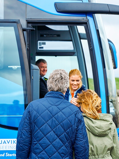 Tourists boarding Reykjavik Sightseeing transfer bus in Iceland.