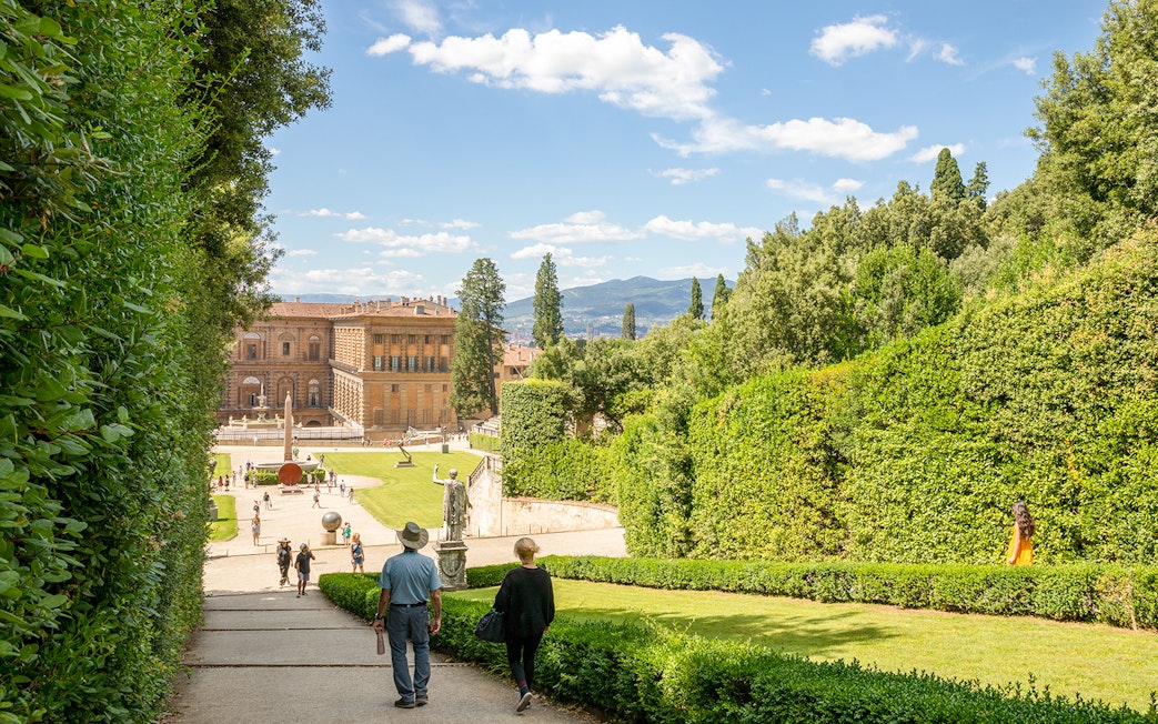 Visitors walking towards Pitti Palace through Boboli Garden in Florence, Italy.