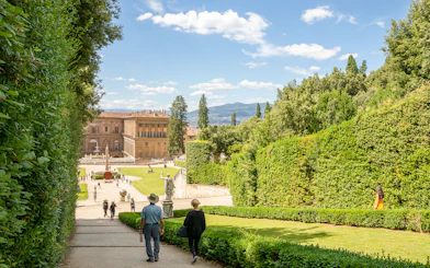 Visitors walking towards Pitti Palace through Boboli Garden in Florence, Italy.