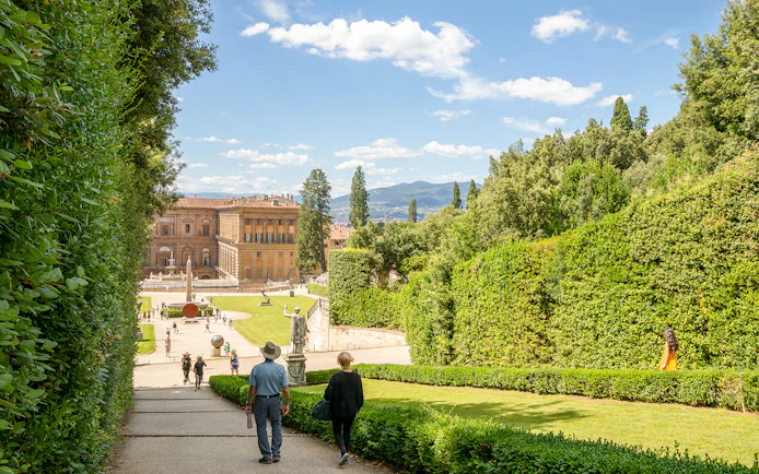 Visitors walking towards Pitti Palace through Boboli Garden in Florence, Italy.