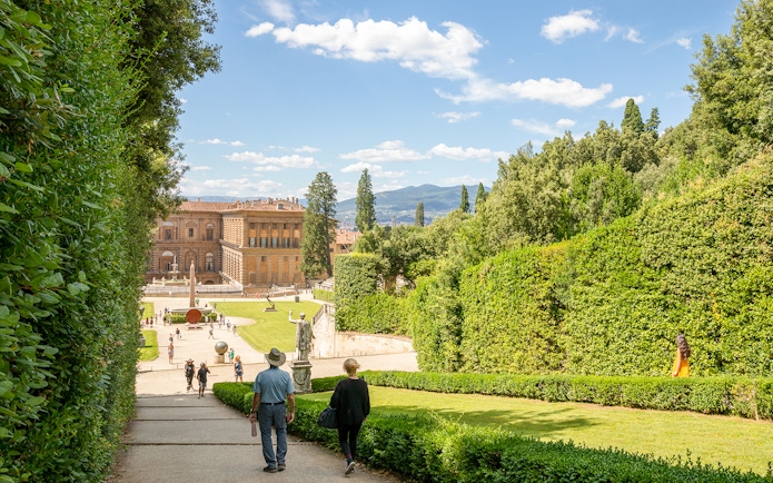 Visitors walking towards Pitti Palace through Boboli Garden in Florence, Italy.